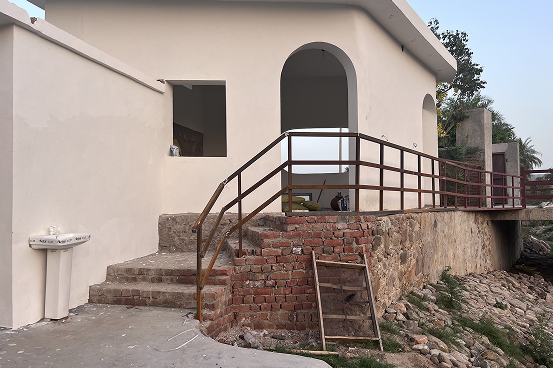 Palms & Pebbles — arched entrance and curved staircase at twilight