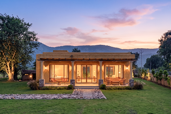 Palms & Pebbles — villa with glowing windows at night