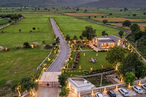 Palms & Pebbles — aerial view of driveway, gardens, and fields