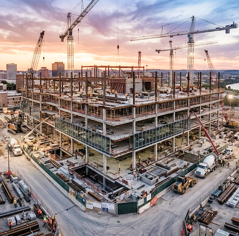Construction site at sunset showing building skeleton